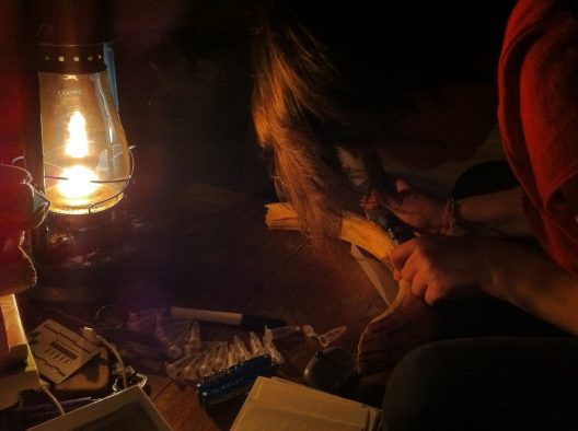 Kendra Chritz sampling hippo canine enamel by kerosene lamplight in Queen Elizabeth National Park.